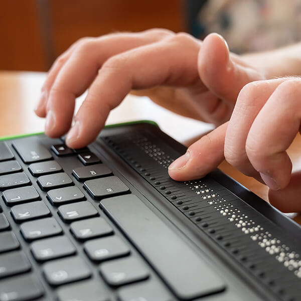 blind website user typing on a custom keyboard to access a website