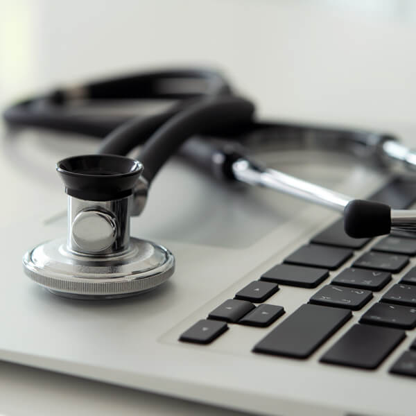 Stethoscope sitting on top of open laptop