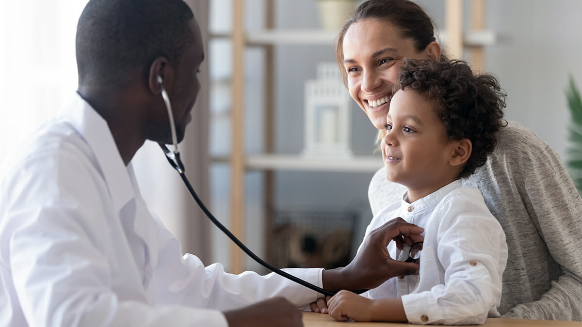 mother smiles at son's pediatrician whom she found because of marketing for doctors
