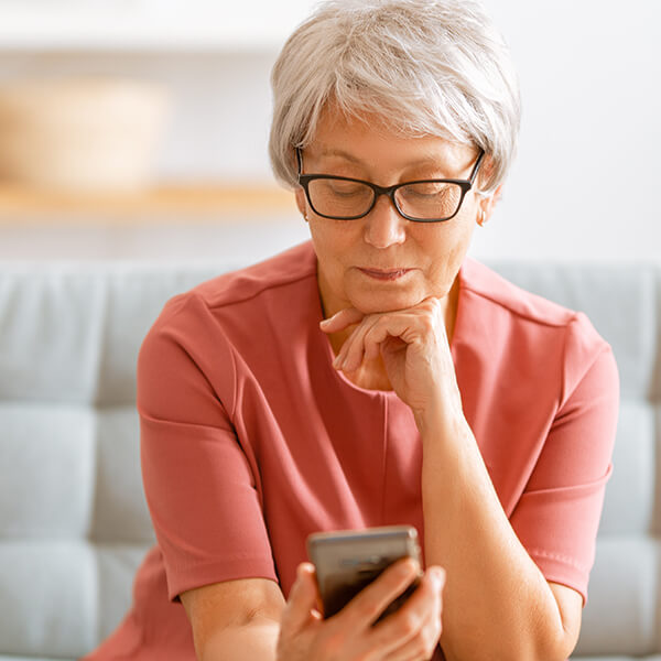 woman using her smartphone to look at social media marketing healthcare services